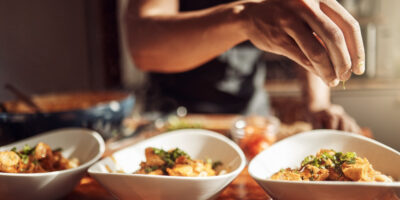 A man adding garnishes to a meal.