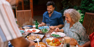 A multigenerational family eating together outdoors.