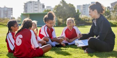 A woman coaching a girl’s football team.