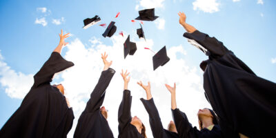 A group of graduates throwing their caps.