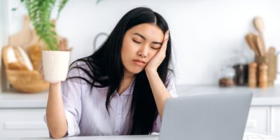 A woman falling asleep at her desk.