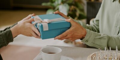 A person gifting a wrapped birthday present.