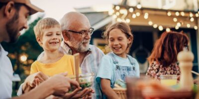 A grandfather laughing with his grandchildren.