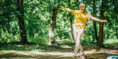 A woman doing balancing exercises outdoors.