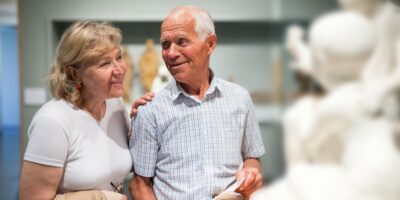 A couple looking at a statue in a museum.
