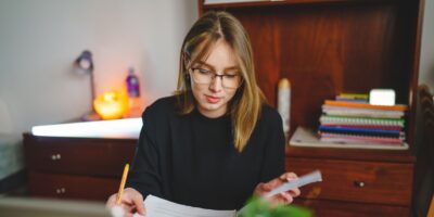 A young woman writing in a notebook.