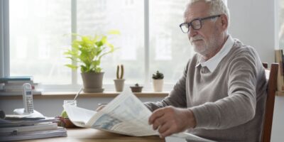 A man reading a newsletter at home.