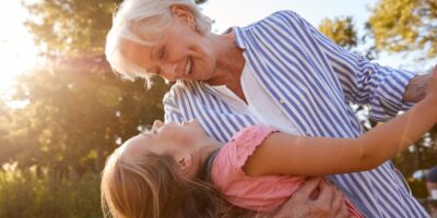 A grandmother playing with her granddaughter outside.