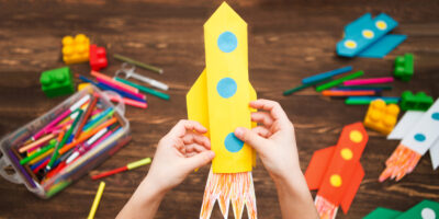 A child making a rocket out of paper.