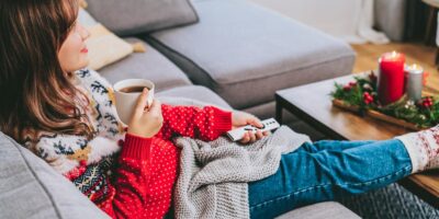 A woman relaxing wearing a Christmas jumper.